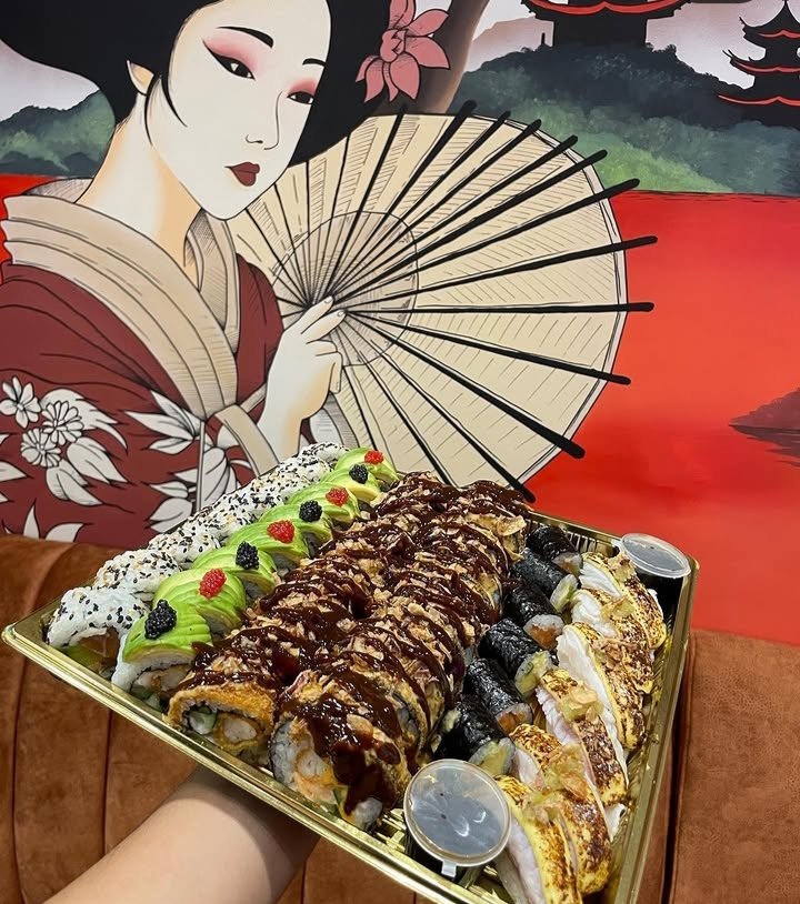 Plateau signature de sushis Sushi House, présenté devant une fresque japonaise